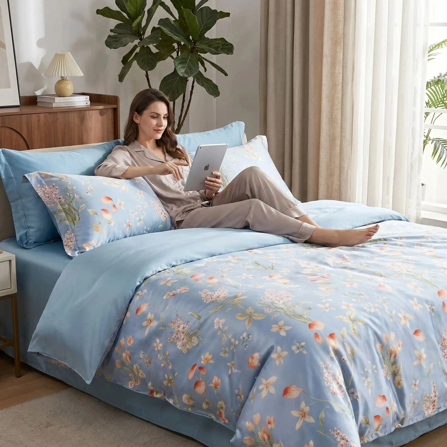 Femme avec tablette sur parure de lit bleue Soie Naturelle