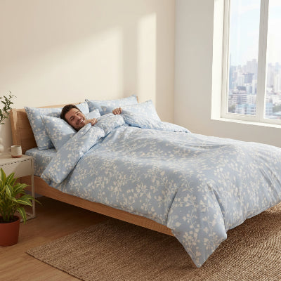 Homme souriant sous housse de couette bleu floral