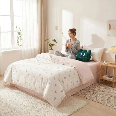 Jeune femme sur parure de lit coton premium avec café