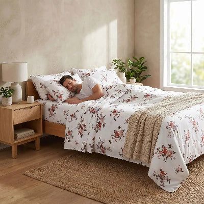 homme endormi sur drap plat blanc floral éclatant