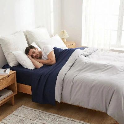 homme endormi sur drap plat bleu foncé polyester frais