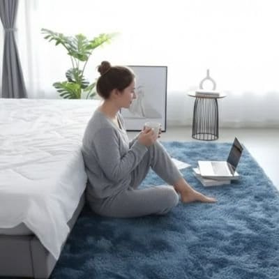 Femme avec ordinateur sur tapis descente de lit bleu 