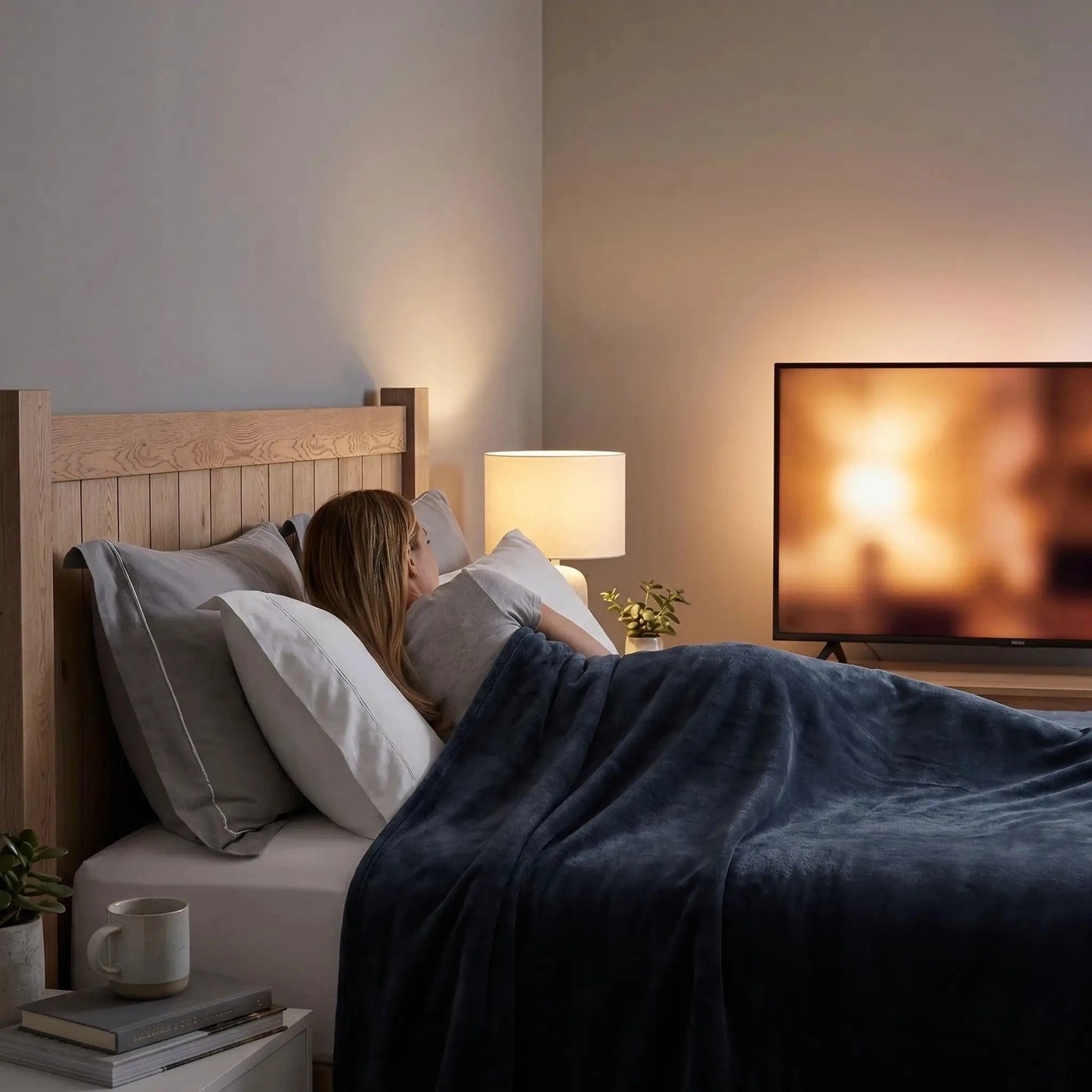 Femme regarde télé sous couverture grise ultra douce 