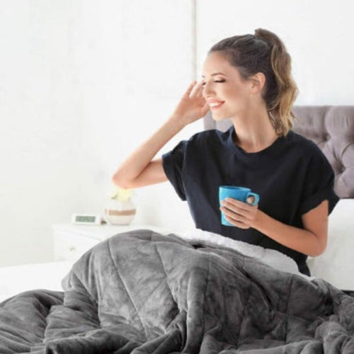 Femme souriante avec café sous couverture lestee grise sherpawhite™ 
