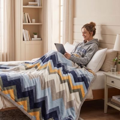 Femme souriante avec ordinateur sous couverture chevron ™