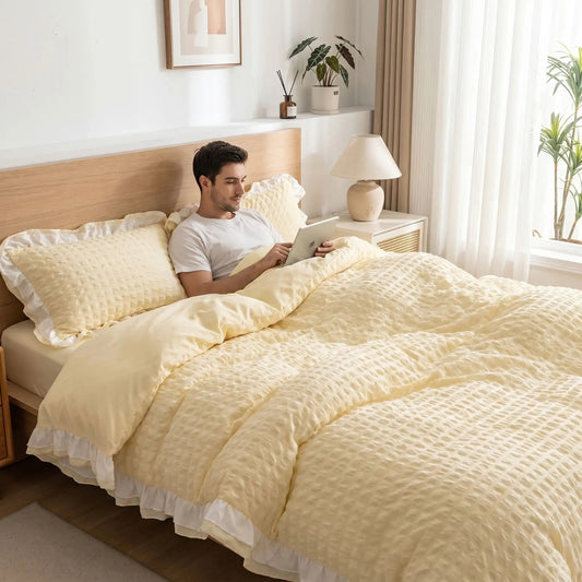 Homme avec tablette sur parure de lit jaune dentelle seersucker
