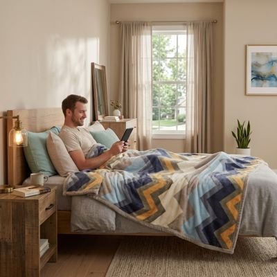 Homme couché avec tablette sous couverture chevron ™