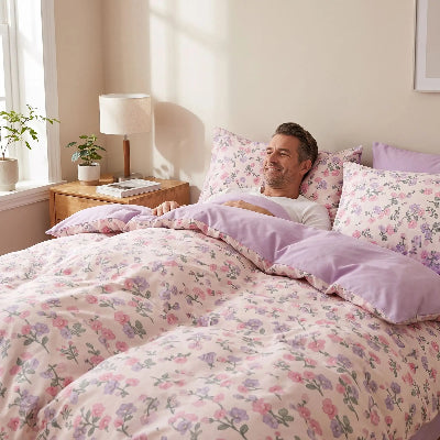 Homme couché sous housse de couette douceur rose floral