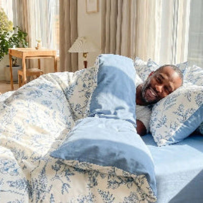 Homme souriant sous housse de couette douceur rose romantique