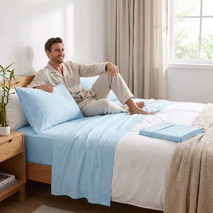Homme souriant sur drap d'été bambou fraîcheur bleu dans chambre