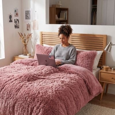 Jeune femme avec ordinateur sur parure de lit 200x200 rose