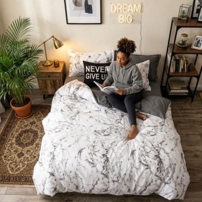 Jeune femme étudie sur parure de lit blanche Élégance Premium