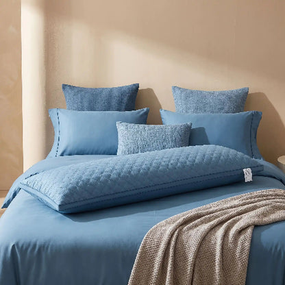 Traversin 180 ferme bleu sur lit avec draps bleus