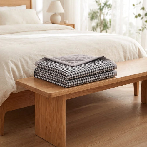 Couverture double face sur table près lit dans chambre
