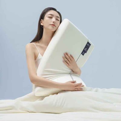 femme assise avec l'oreiller à mémoire de forme Plushpillow blanc
