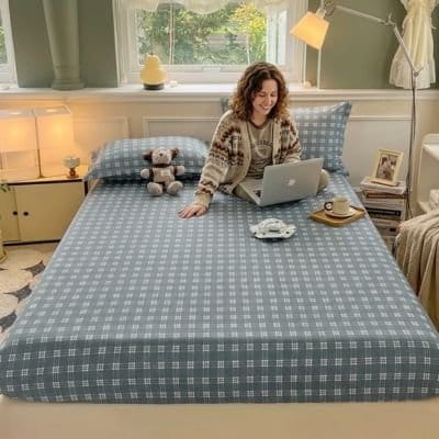 femme avec ordinateur sur drap housse gris ajustement parfait