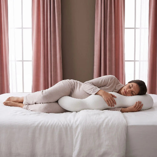 femme enceinte endormie avec traversin ergonomique cervical blanc sur lit cote gauche