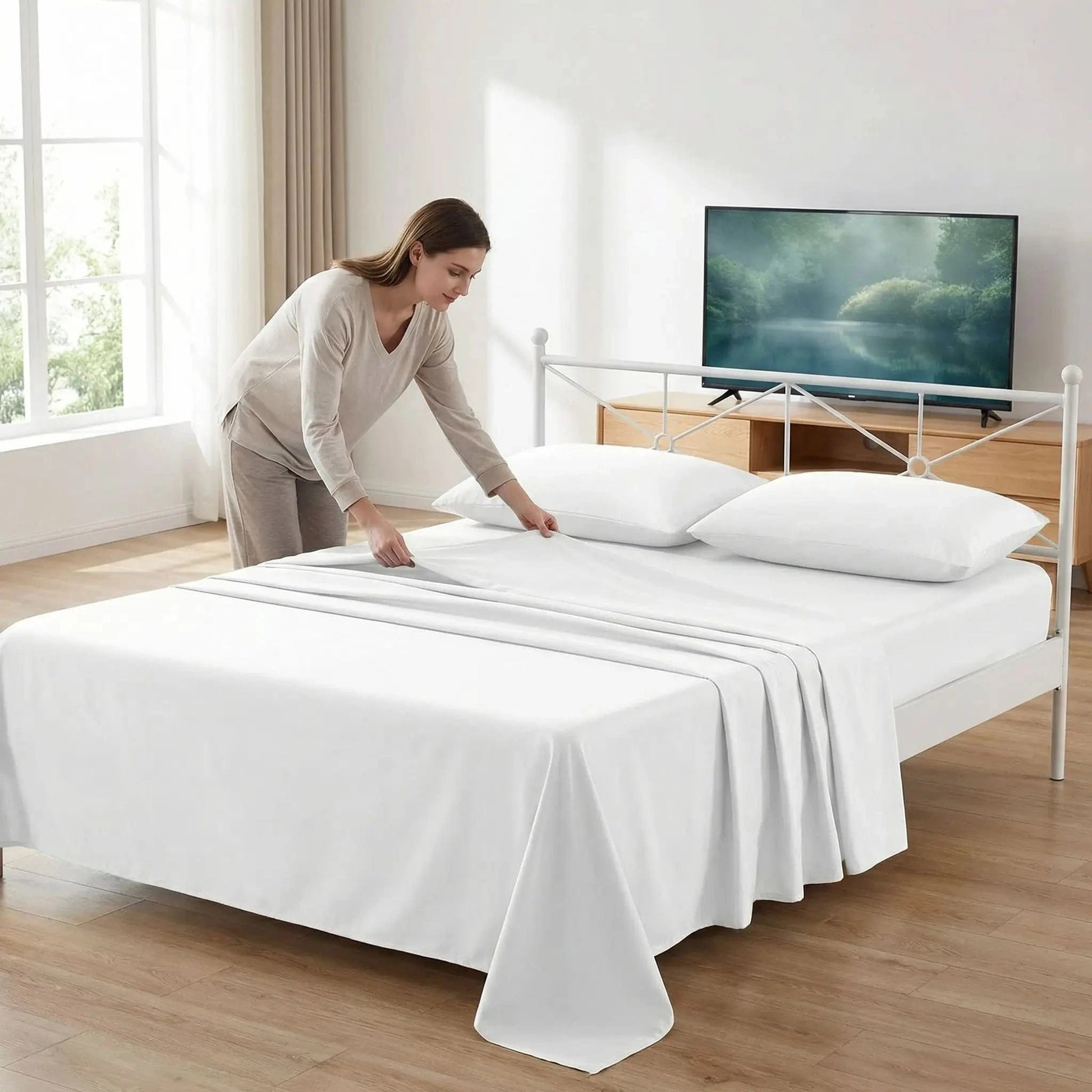 femme plie son drap plat blanc côté télévision