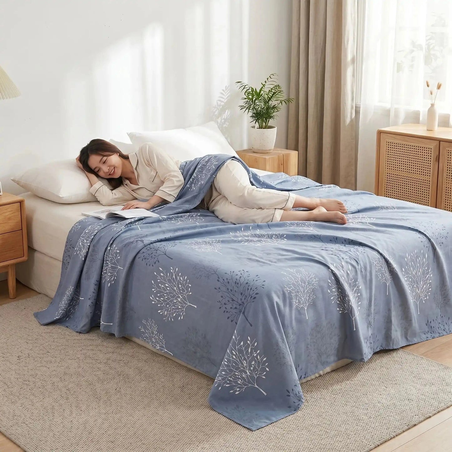 femme souriante couchée sur drap plat bleu floral pur coton 500 