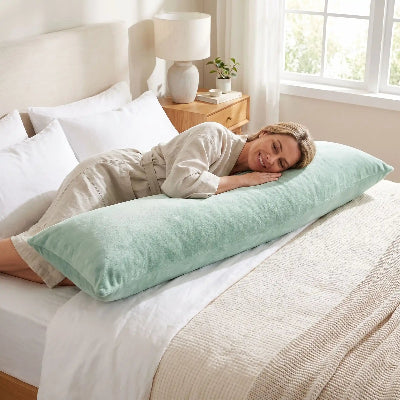 femme souriante couchée sur traversin Otautau™ vert clair