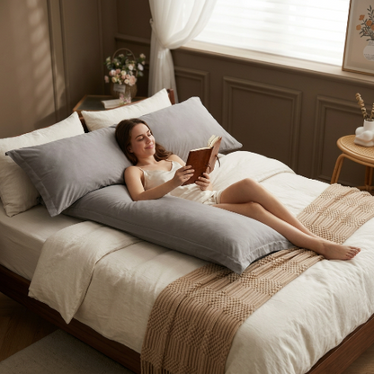  femme sur lit sourit avec taie traversin grise 