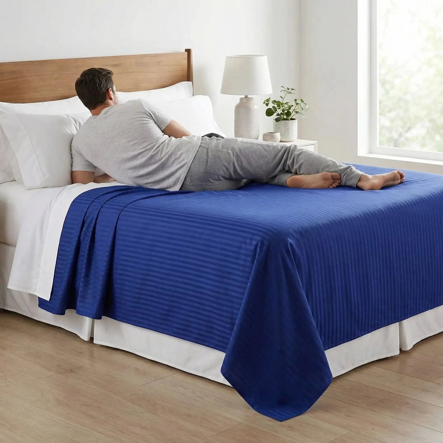 homme couché sur drap plat bleu marine coton 600 fils