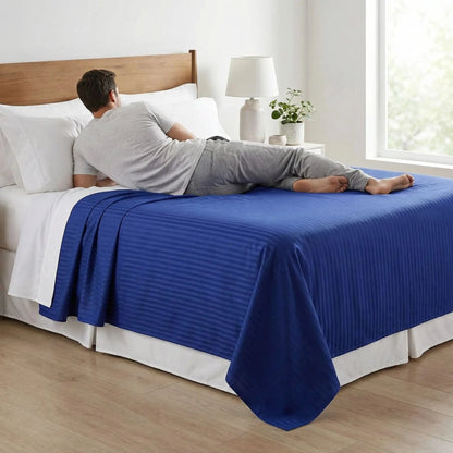 homme couché sur drap plat bleu marine coton 600 fils