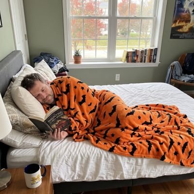 homme lit livre enveloppé sous couverture tissu flanelle orange
