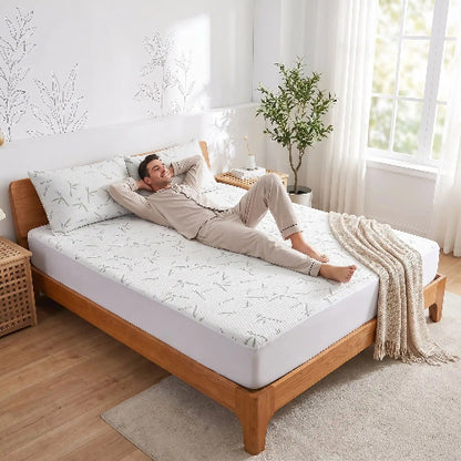 homme souriant couché sur drap housse frais vert clair sur dos