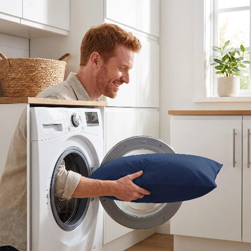 homme souriant lave dans machine taie 50x70 bleue