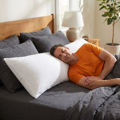 homme en orange endormi tête sur traversin blanc