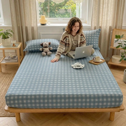 jeune femme sourit avec ordinateur sur drap housse bleu