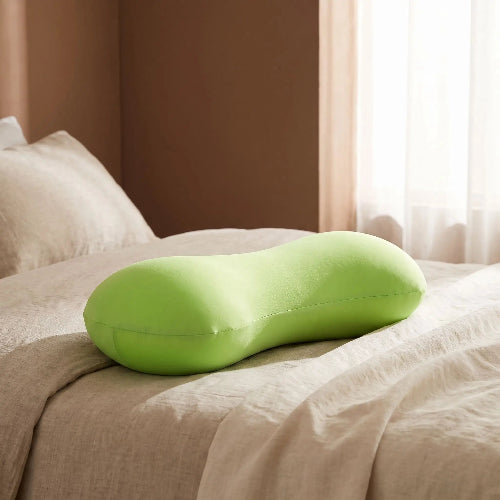 traversin ergonomique cervical vert avec draps sur lit 